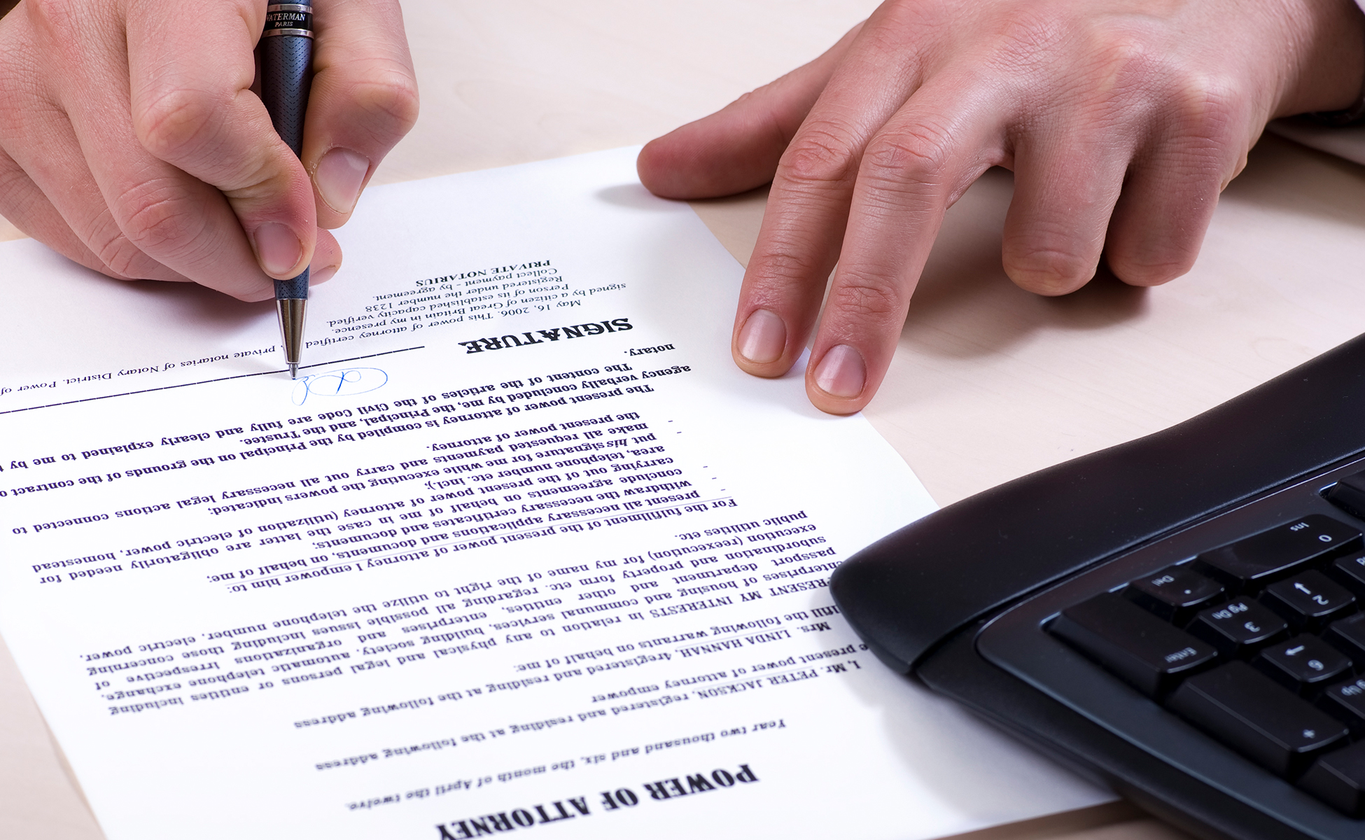 man signing a power of attorney paper